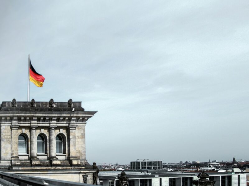 German flag on top of the Bundestag building in Berlin as Germany’s 2027 budget increases defense spending and public borrowing.